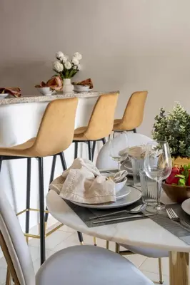 a table with chairs and a table with plates and wine glasses at Frank Porter - Al Arta 4 in Dubai
