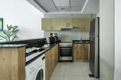 a kitchen with a stainless steel refrigerator and a dishwasher at ShoresInn - Stellar 2BR with charming Marina View in Dubai