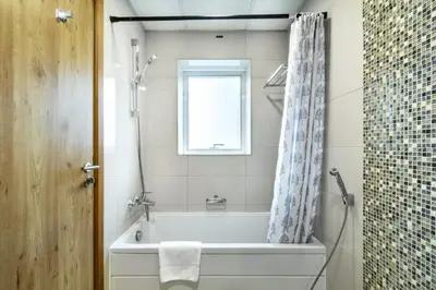 a bathroom with a bath tub and a window at ShoresInn - Stellar 2BR with charming Marina View in Dubai