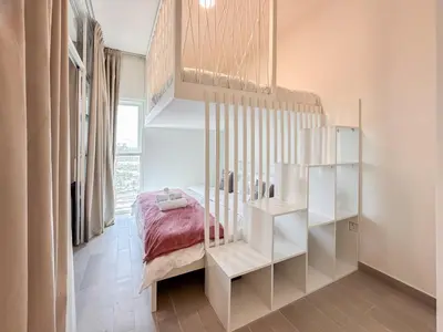 a bedroom with a bed and a book shelf at Cozy 1 Bedroom in Golfville Dubai Hills in Dubai