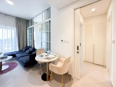 a living room with a couch and a table at Cozy 1 Bedroom in Golfville Dubai Hills in Dubai