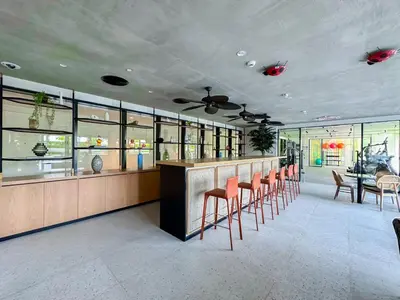 a bar with orange stools in a restaurant at Cozy 1 Bedroom in Golfville Dubai Hills in Dubai