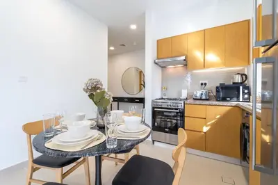 a kitchen with a table and chairs in a kitchen at Mystic - Stylish High-Rise Living with Premium Amenities in Dubai