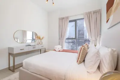 a white bedroom with a bed and a mirror at Mystic - Stylish High-Rise Living with Premium Amenities in Dubai