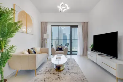 a living room with a tv and a couch and a table at Burj Royale - Luxury Stay with Panoramic Burj Khalifa & Fountain View in Dubai