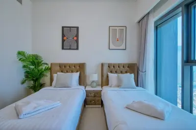 two beds in a room with a window at Burj Royale - Luxury Stay with Panoramic Burj Khalifa & Fountain View in Dubai