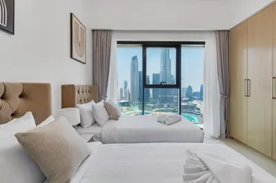 a hotel room with two beds and a large window at Burj Royale - Luxury Stay with Panoramic Burj Khalifa & Fountain View in Dubai