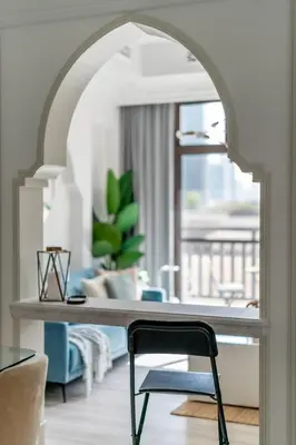 an archway in a living room with a table and a chair at GuestReady - Downtown lux near Burj Khalifa in Dubai
