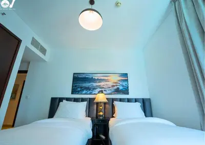 two twin beds in a room with a lamp at Luxurious 2BR I Burj Khalifa View I Downtown Dubai in Dubai