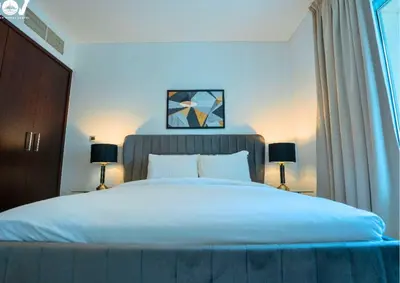 a bedroom with a large white bed with two lamps at Luxurious 2BR I Burj Khalifa View I Downtown Dubai in Dubai