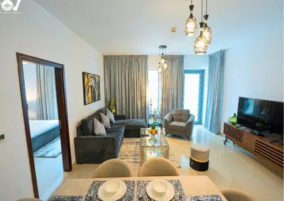 a living room with a couch and a tv at Luxurious 2BR I Burj Khalifa View I Downtown Dubai in Dubai