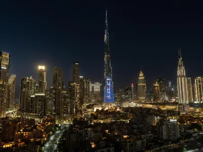 a city skyline at night with a lit up skyscraper at Bespoke 1 Bedroom Apartment I Burj Khalifa & Fountain Views I Free Gym, Pool, Wi-Fi, Parking & PS5 I by Skyline Serenity in Dubai