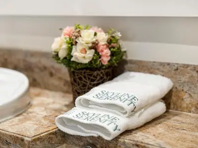 a bunch of towels on a counter with a vase of flowers at Bespoke 1 Bedroom Apartment I Burj Khalifa & Fountain Views I Free Gym, Pool, Wi-Fi, Parking & PS5 I by Skyline Serenity in Dubai
