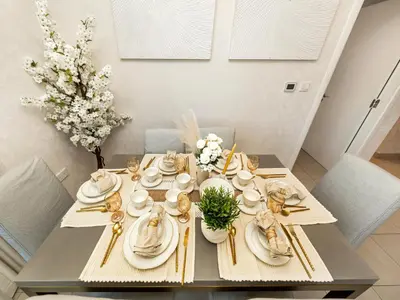 a dining room table with white plates and gold utensils at Bespoke 1 Bedroom Apartment I Burj Khalifa & Fountain Views I Free Gym, Pool, Wi-Fi, Parking & PS5 I by Skyline Serenity in Dubai