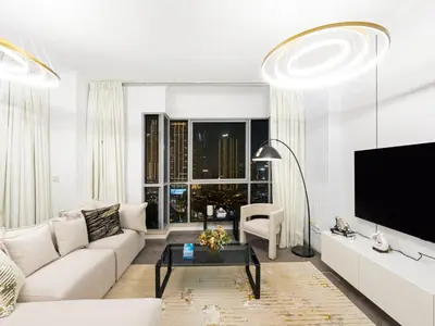 a living room with a white couch and a tv at Luxe 4 bedroom Apartment I Burj Khalifa & Fountain Views I Free Gym, Pool, Parking, Wi-Fi and PS5 I by Skyline Serenity in Dubai