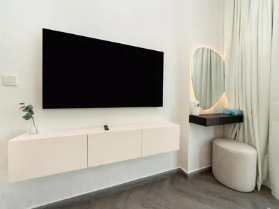 a living room with a tv on a wall at Luxe 4 bedroom Apartment I Burj Khalifa & Fountain Views I Free Gym, Pool, Parking, Wi-Fi and PS5 I by Skyline Serenity in Dubai