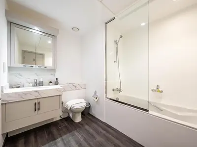 a white bathroom with a toilet and a shower at Luxe 4 bedroom Apartment I Burj Khalifa & Fountain Views I Free Gym, Pool, Parking, Wi-Fi and PS5 I by Skyline Serenity in Dubai