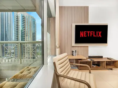 a living room with a netflix sign on a wall at New Burj Khalifa & Fountain Views & Work station in Dubai
