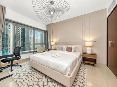 a bedroom with a large white bed and a desk at New Burj Khalifa & Fountain Views & Work station in Dubai