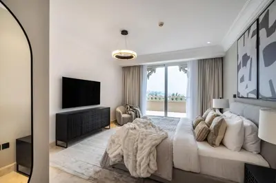 a white bedroom with a bed and a television at The Smart Concierge - Grandeur Residence - Maurya in Dubai