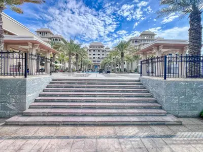 a set of stairs in front of a building with palm trees at The Smart Concierge - Grandeur Residence - Maurya in Dubai