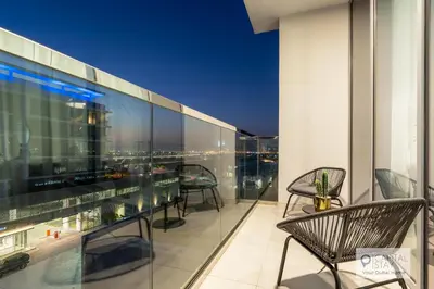 a balcony with chairs and tables on a building at 2 Bed Apt in District One Dubai - Lagoon Views in Dubai