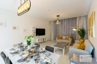 a living room with a dining table and a couch at 2 Bed Apt in District One Dubai - Lagoon Views in Dubai