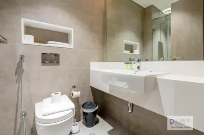a bathroom with a white sink and a toilet at 2 Bed Apt in District One Dubai - Lagoon Views in Dubai