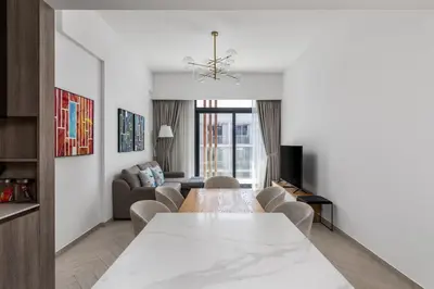 a living room with a long table and chairs at Waves - Luxurious Comfort with City Views in Oxford 212 in Dubai