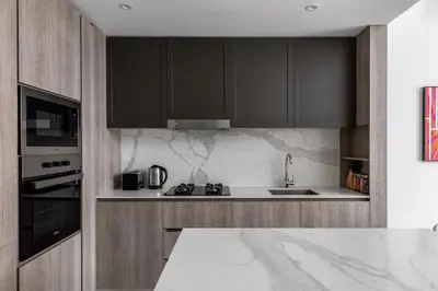 a kitchen with black cabinets and a white counter top at Waves - Luxurious Comfort with City Views in Oxford 212 in Dubai