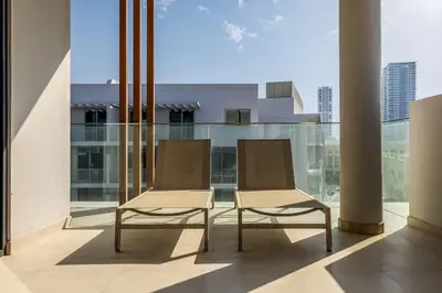 two chairs sitting on a balcony in a building at Waves - Luxurious Comfort with City Views in Oxford 212 in Dubai