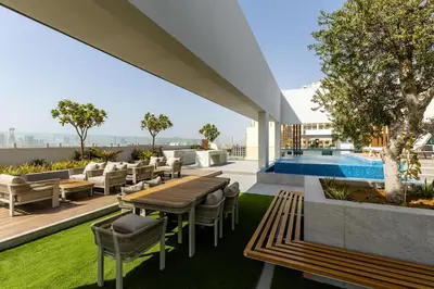 a patio with a table and chairs and a pool at Waves - Luxurious Comfort with City Views in Oxford 212 in Dubai