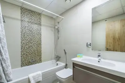 a bathroom with a tub and a sink and a toilet at ShoresInn - Fantastic Marina Waterfront View in Dubai