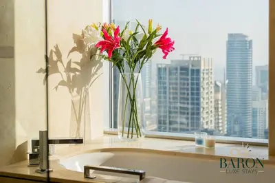 a vase of flowers sitting on a counter next to a window at The Haven in Dubai