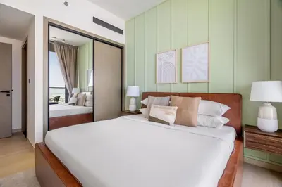 a bedroom with a large white bed and a mirror at GuestReady - Glamorous stay at Binghatti Corner in Dubai