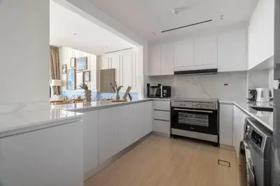 a white kitchen with white cabinets and a stove at GuestReady - Glamorous stay at Binghatti Corner in Dubai