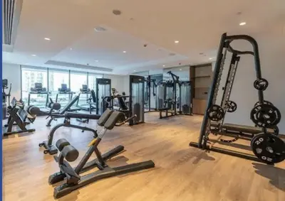 a gym with several tread machines in a room at Spacious 3BR plus maids Burj Khalifa View in Dubai