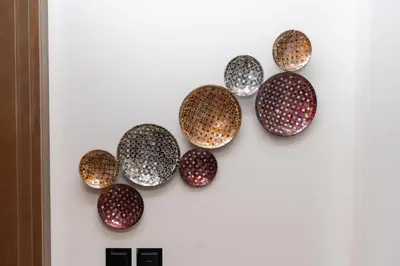 a group of nine copper bowls on a wall at Ahlan HH - Luxury 2BR in Sobha Creek Vistas in Dubai