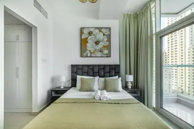 a bedroom with a large bed and a window at ShoresInn - Waterfront in Heart of Dubai Marina in Dubai