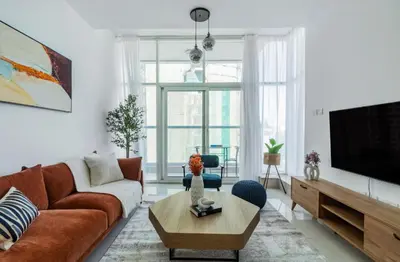 a living room with a couch and a tv at ShoresInn - Waterfront in Heart of Dubai Marina in Dubai