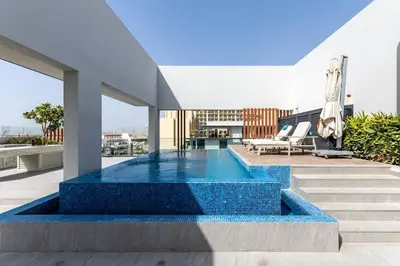 a house with a swimming pool on a roof at Waves - Elegant Oxford 212 Studio in JVC with City Views in Dubai