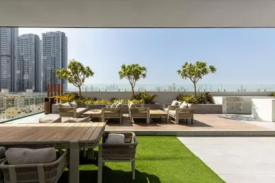 a patio with a table and chairs on a roof at Waves - Elegant Oxford 212 Studio in JVC with City Views in Dubai
