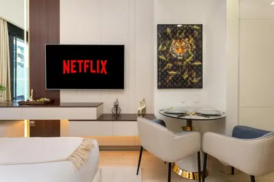 a living room with a netflix sign on the wall at Ahlan HH - Stylish Studio with Pool & Gym, Azizi Riviera 26 in Dubai