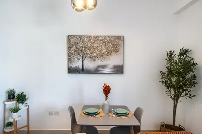 a dining room with a table and a picture on the wall at ShoresInn - Heavenly Escape with Marina View in Dubai