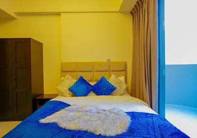 a bedroom with a bed with a blue blanket and blue pillows at NiceVisit Merano 1BD Business Bay in Dubai