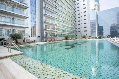 a large swimming pool in a building with tall buildings at NiceVisit Majestine Stuido Business bay in Dubai