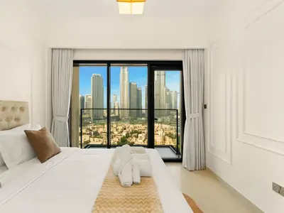 a bedroom with a white bed with a large window at Burj Khalifa View Luxe 2BR, 5 Mins walk to Dubai Mall in Dubai