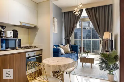 a kitchen and living room with a table in a room at AWS Holiday Homes - Lux Gateaway near Dubai Mall in Dubai
