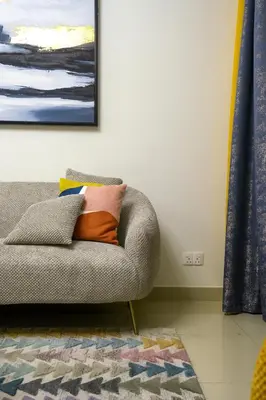 a living room with a couch and a painting on the wall at CH Skyline Retreat - Cozy 1BR Apt With Burj Khalifa and Fountain Views in Dubai