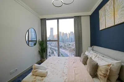 a bedroom with a large bed and a large window at CH Skyline Retreat - Cozy 1BR Apt With Burj Khalifa and Fountain Views in Dubai